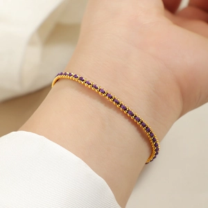 Detail of red and gold woven bracelet with stainless steel beads on female wrist
