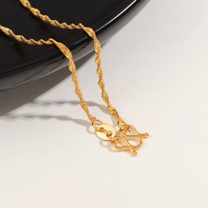 Detailed macro view of 24K gold-plated water wave chain with an S-hook closure
