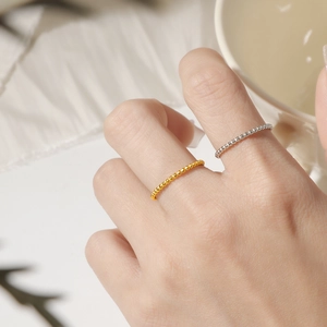 Minimalist 18K gold and silver titanium steel beaded rings worn stacked on fingers