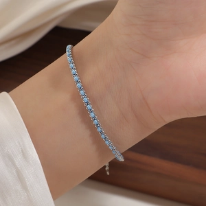 Close-up of minimalist silver chain bracelet with shimmering blue glitter inlay