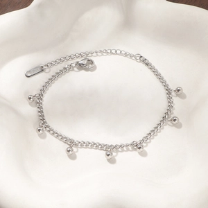 Detail of silver stainless steel chain bracelet with dangling beads and lobster clasp