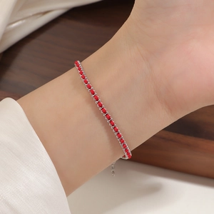 Detailed close-up of woven red rope bracelet with silver steel beads on wrist