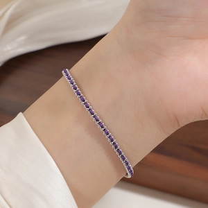 Close-up of elegant silver beaded chain bracelet with purple glitter stone on wrist