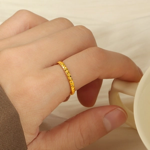 Close-up of 18K gold plated ring with geometric pyramid texture worn on index finger