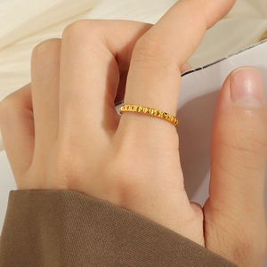 Macro shot of gold-plated stainless steel ring featuring textured pyramid rivet details