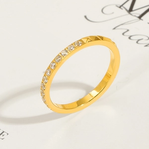 Nahaufnahme eines vergoldeten Titanrings mit halber Pavé-Diamantierung und Nietentextur