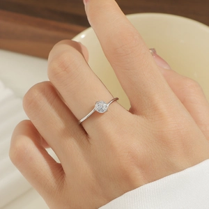 Nahaufnahme eines minimalistischen Titanstahlrings mit Zirkonia-Solitär an einem Frauenfinger