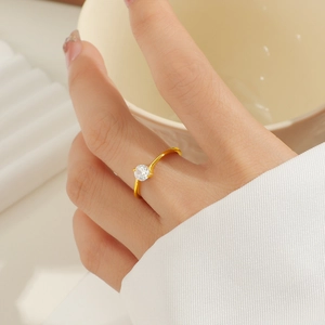 Makro-Detail des minimalistischen Titanstahlrings in Gold mit vierzackigem Zirkonia