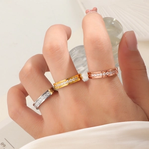 Detailansicht von dreifarbigen Titanstahlringen mit Pavé-Diamanten an einer Hand