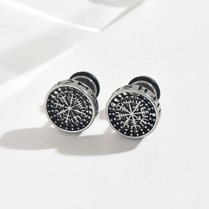 Macro view of vintage Viking Vegvisir compass stud earrings with Runic engravings