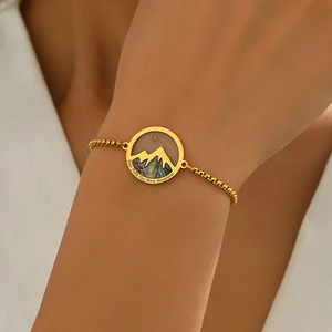 Detail of gold mountain pendant with 'Your Faith Can Move Mountains' engraving and abalone shell