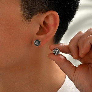 Retro silver skull stud earrings for men featuring a gothic circular embossed design