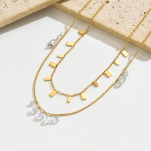 Collier double rang doré avec pendentifs en cristal rond et plaques en métal poli