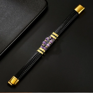 Détail macro du bracelet en cuir tressé noir pour hommes avec perles violettes et fermoir doré