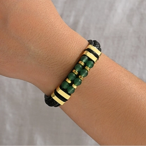 Vue macro d'un bracelet en cuir tressé pour homme avec perles vertes et touches dorées