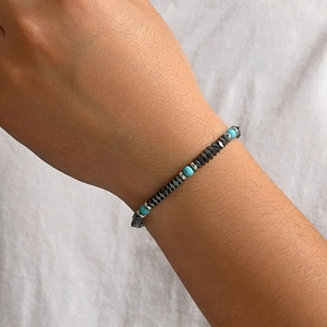 Close-up of beaded bracelet with hematite and turquoise stones on a wrist