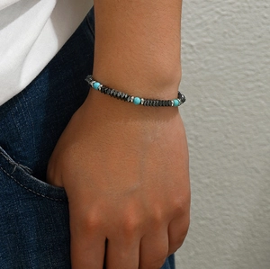 Detail showing natural stone bead bracelet with faceted hematite and blue accents