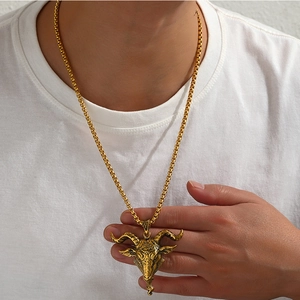 Gros plan d'un collier avec pendentif tête de bélier doré au design rétro texturé