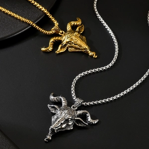 Détail macro de pendentifs tête de chèvre en or et argent avec chaînes sur fond noir