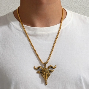Vue détaillée d'un collier avec pendentif tête de chèvre dorée porté par un mannequin