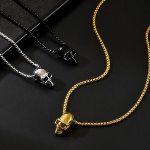 Détails de pendentifs tête de mort en or, argent et noir sur chaînes mailles box