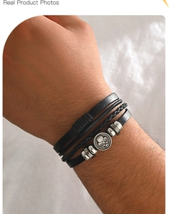 Detail of multi-layer black leather bracelet featuring vintage silver skull and metal beads