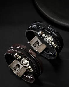 Detail of multi-layer braided leather bracelet with skull emblem and metal clasp
