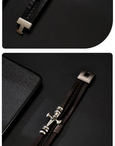 Detailed close-up of multilayer leather bracelet with silver skull and cross charms