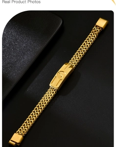 Close-up of golden braided chain bracelet with magnetic buckle on black background