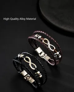 Detail of multi-layer braided leather bracelet featuring infinity symbol and metal clasp