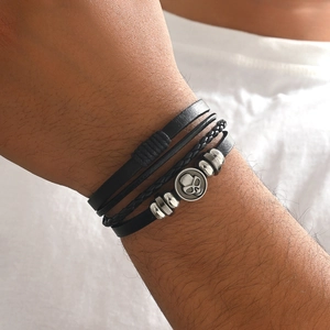 Men's multilayer black leather bracelet with silver skull charm and woven cord strands