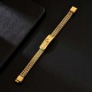 Golden woven bracelet with a musical note charm on a dark background in diagonal view