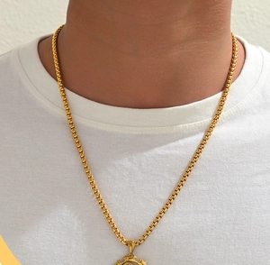 Detalle de un collar con colgante de engranaje de doble capa para hombre con cadena dorada