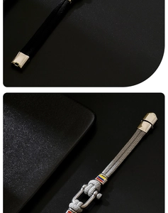 Detail of horseshoe clasp and bicolor braided bracelet on black matte background