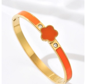 Vue détaillée du bracelet trèfle avec émail orange et cristaux étincelants