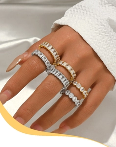Détail de bagues élégantes avec zircons et pierres à taille émeraude et ronde