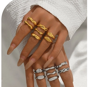 Dettaglio di anelli minimalisti in acciaio inossidabile oro e argento con design lucido