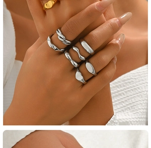 Dettaglio di un set di anelli minimalisti in acciaio inossidabile argento indossati sulle dita