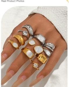 Close-up of stacked gold and silver rings with mother-of-pearl and zircon insets