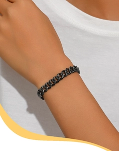 Dettaglio del bracciale a catena nera opaca al polso per uno stile urbano minimal
