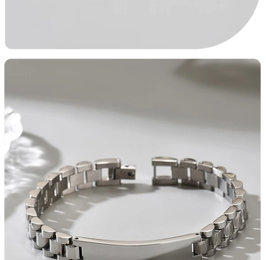 Close-up of polished silver titanium steel watch-style link bracelet with metal plate