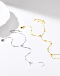 Dettaglio di eleganti anelli a catena in acciaio inossidabile oro e argento su ceramica