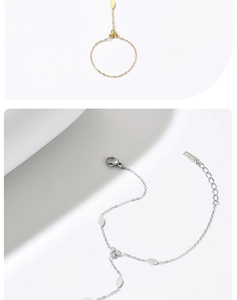 Dettaglio di bracciali a catena in oro e argento con ciondoli a foglia e zirconi lucidi
