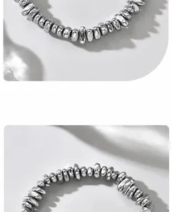 Macro di perle irregolari in acciaio al titanio argento lucido su un bracciale minimalista
