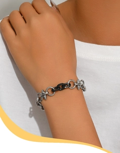 Dettaglio del bracciale punk in acciaio titanio con maglie nere e borchie a punta argento