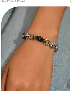 Dettaglio del bracciale punk in acciaio al titanio con maglie nere e punte in metallo argento