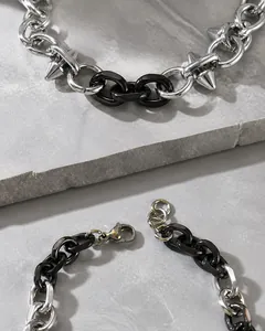 Dettaglio del bracciale punk argento e nero con borchie a punta e chiusura a moschettone