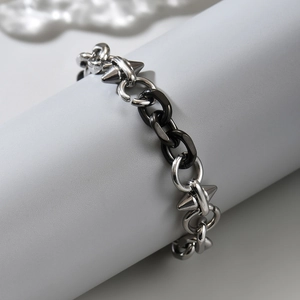 Bracciale punk in acciaio inossidabile nero e argento con punte a cono su supporto
