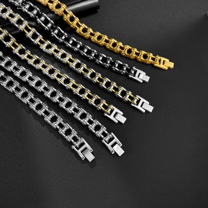 Detail von Fahrradketten-Armbändern in Gold und Silber auf schwarzem Lederhintergrund