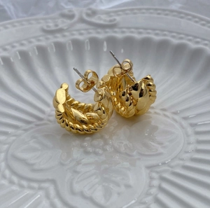 Pendientes de aro trenzados dorados en plato blanco, estilo de metal minimalista